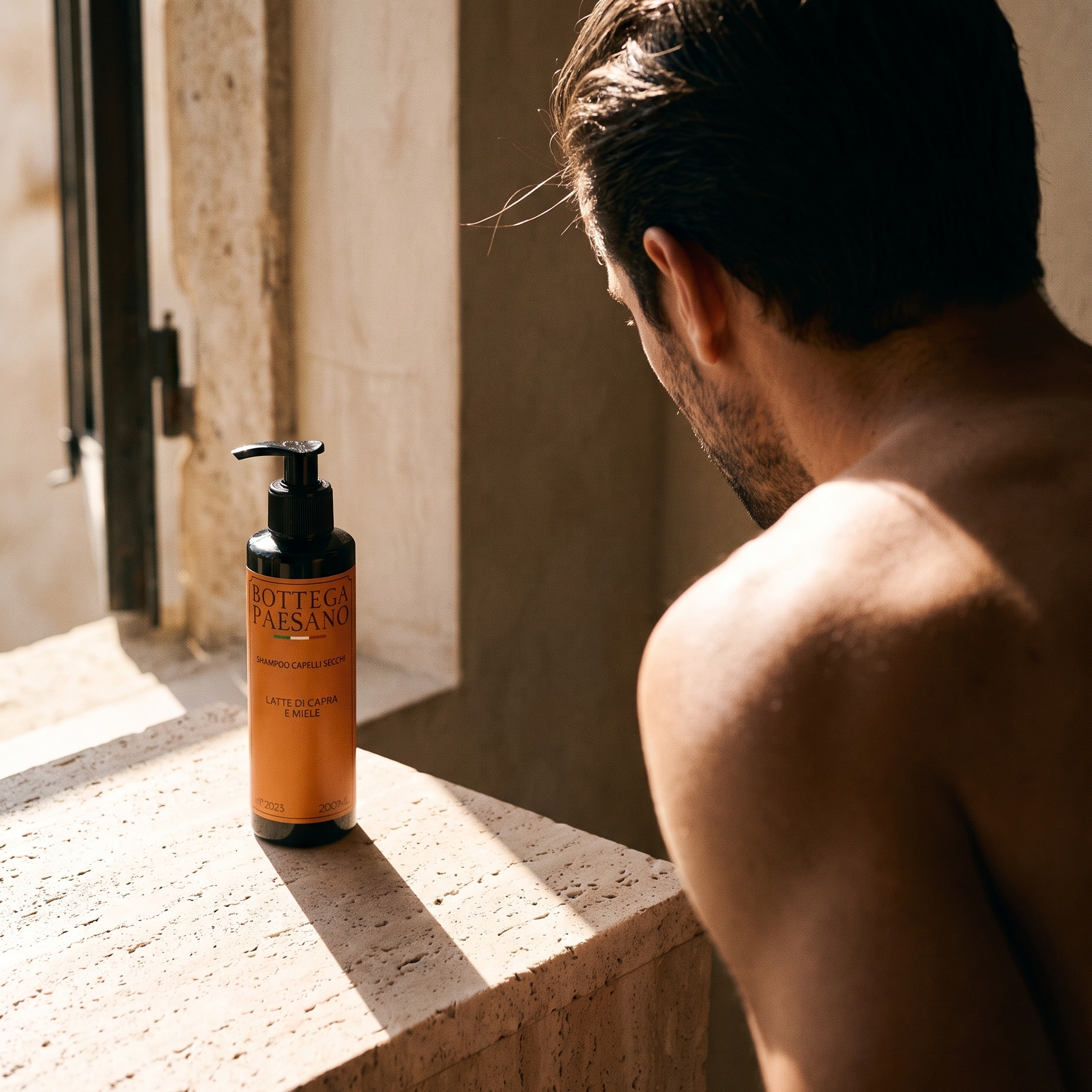 Uomo alla finestra con capelli fini, shampoo volumizzante Bottega Paesano sul davanzale